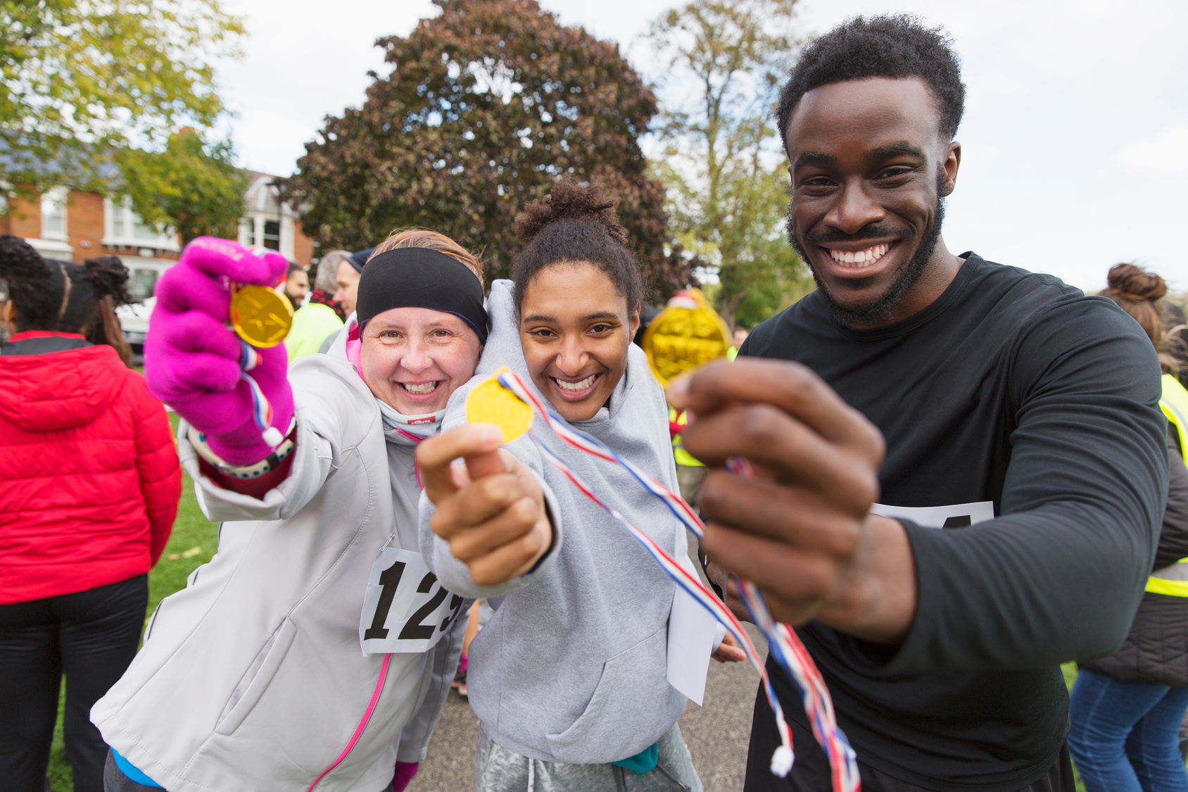 Portrait enthusiastic runners showing medals at charity run in p