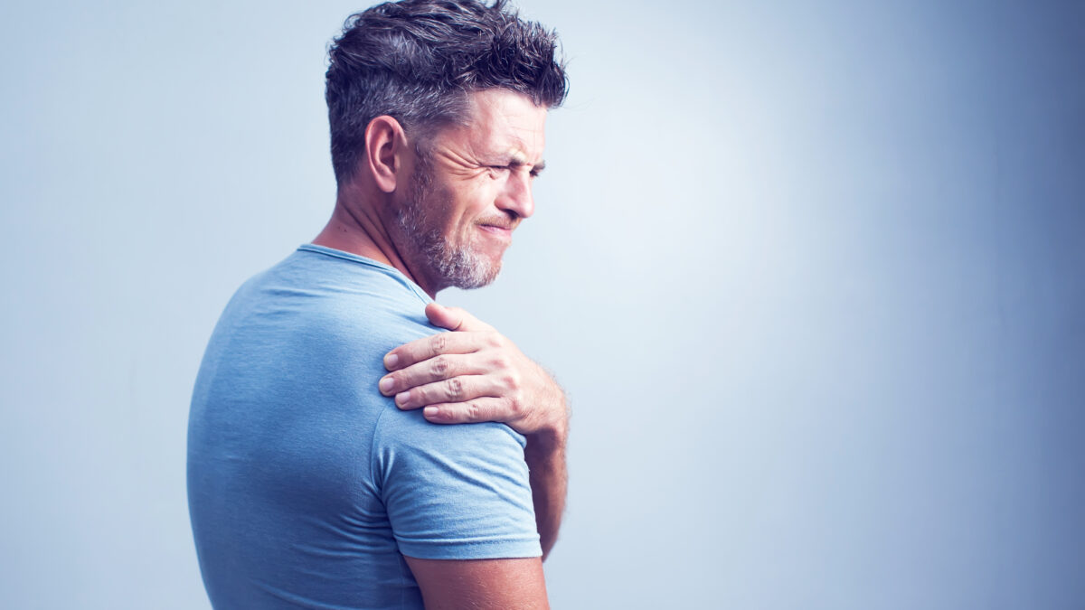 Unhappy man suffering from neck or shoulder pain at home