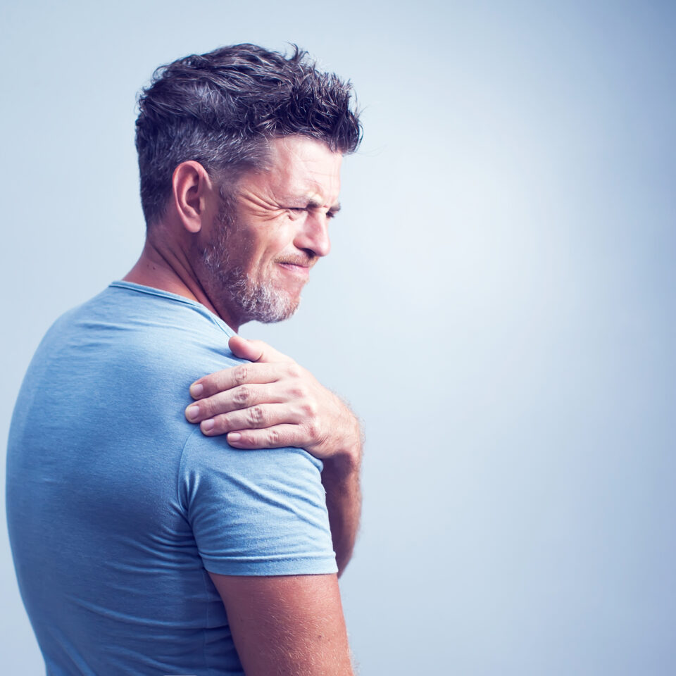 Unhappy man suffering from neck or shoulder pain at home