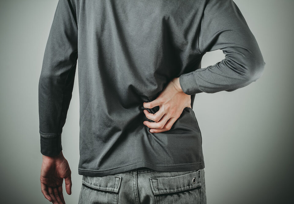 Image of a man holding his sore back