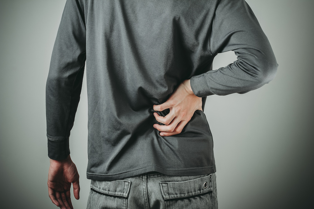 Image of a man holding his sore back