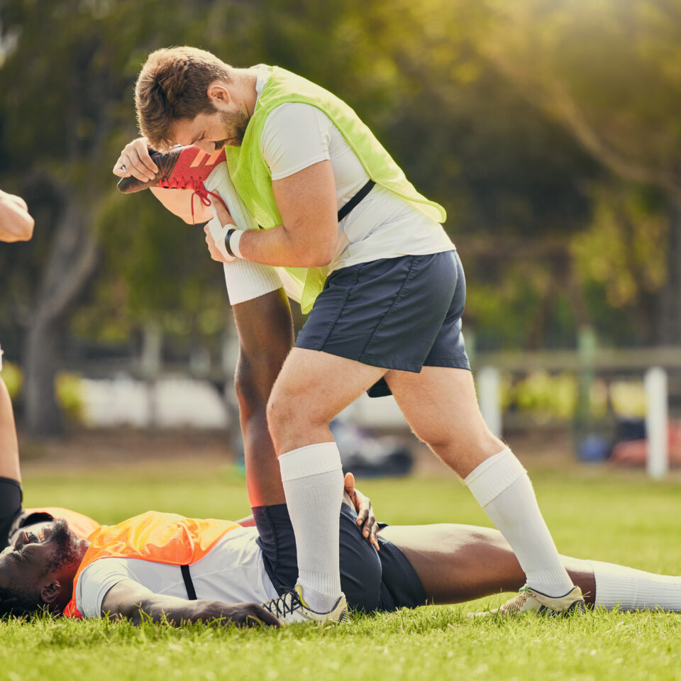 Rugby sports, men training and stretching outdoor on grass field with team warm up for legs. Athlete group together for fitness, exercise and workout for professional sport with coach and teamwork.