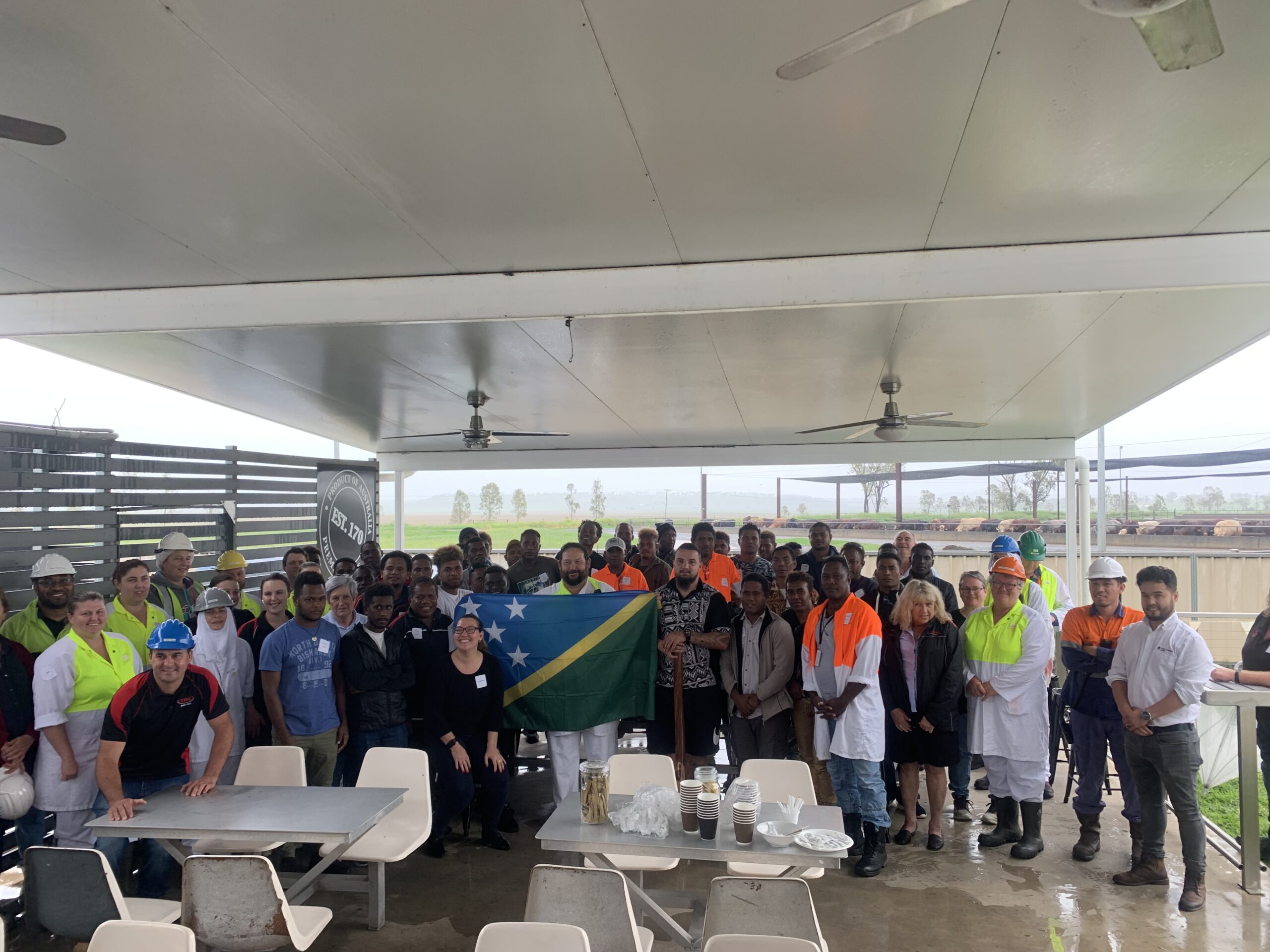 A group of workers from the Solomon Islands are greeted with a welcome to Australia ceremony at JBS Beef City.
