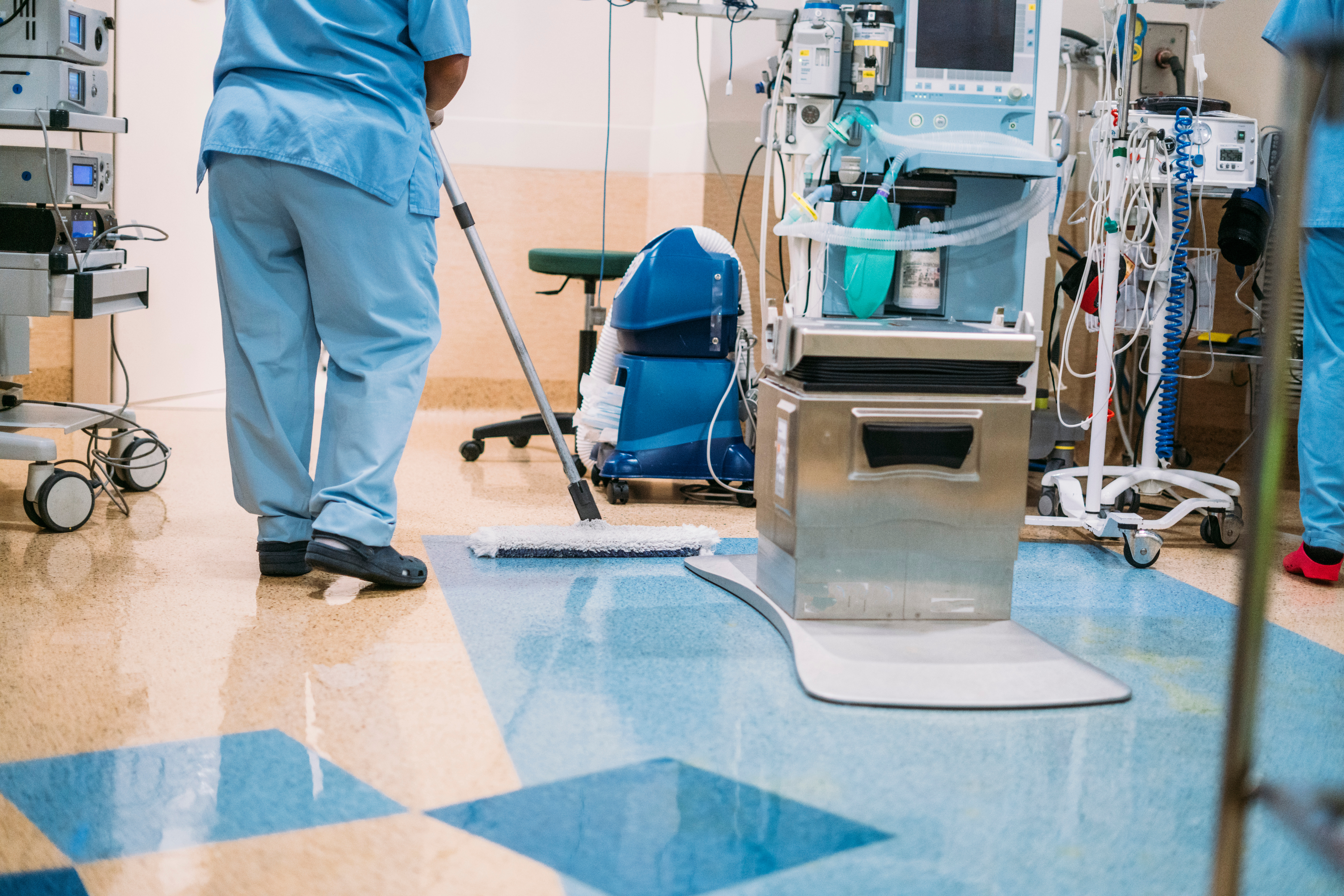 Hospital cleaner maintaining hygiene standards in a clinical ward, representing frontline support staff whose injury risks often go unrecognised.