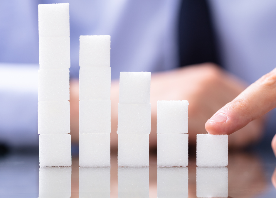 Hand pointing to descending stacked cubes symbolising reduction — visual metaphor for decreasing workplace injuries or claims