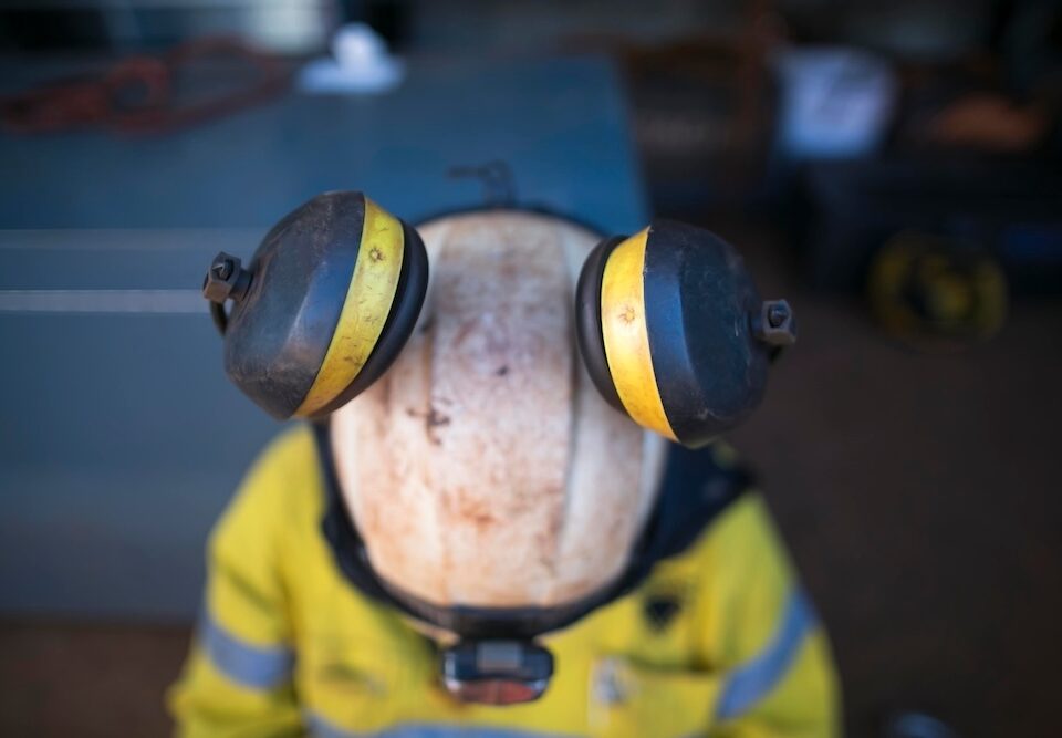 Top view of pictures of ears muffs protection attached clipping into rope access technician full protection helmet at construction site, Sydney Australia