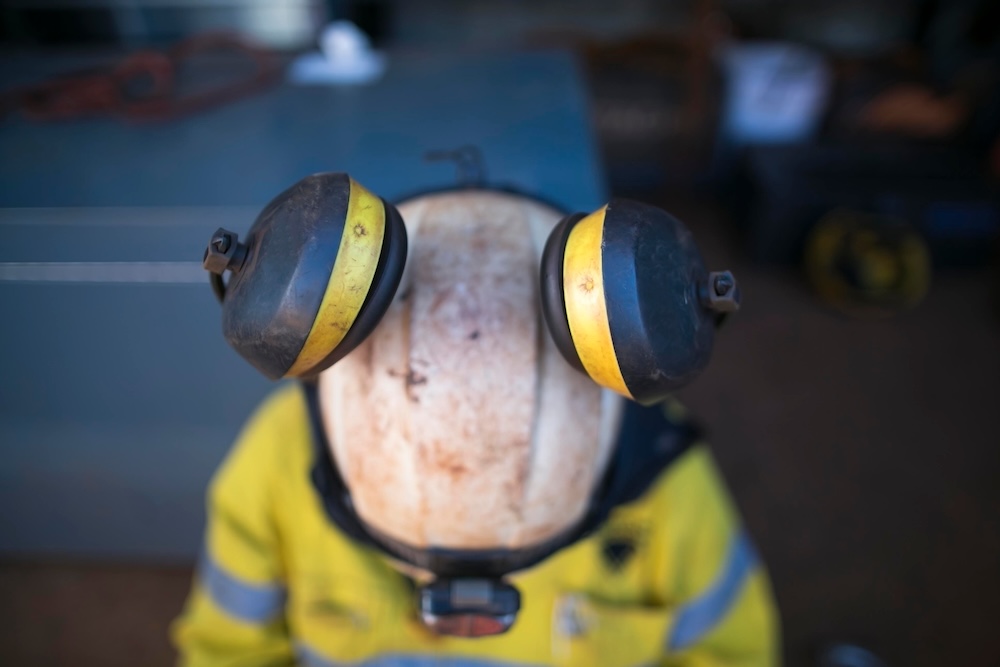 Top view of pictures of ears muffs protection attached clipping into rope access technician full protection helmet at construction site, Sydney Australia